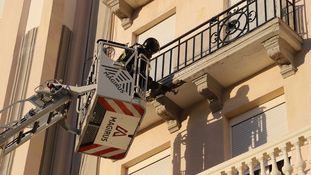 Los bomberos retiran varios cascotes de un edificio de la Plaza de los Reyes
