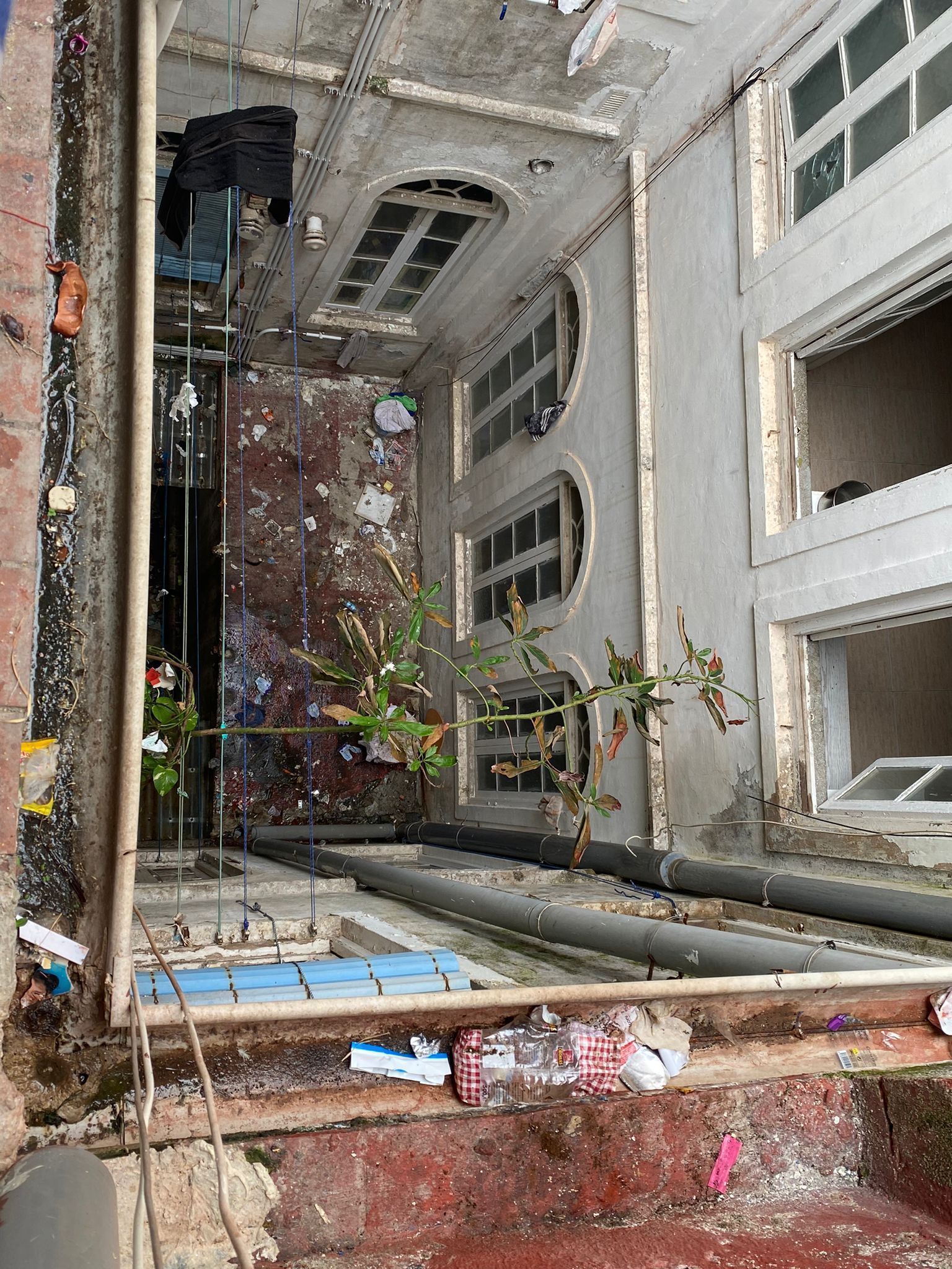 Estado actual del patio del edificio con tuberas rotas excrementos y basura