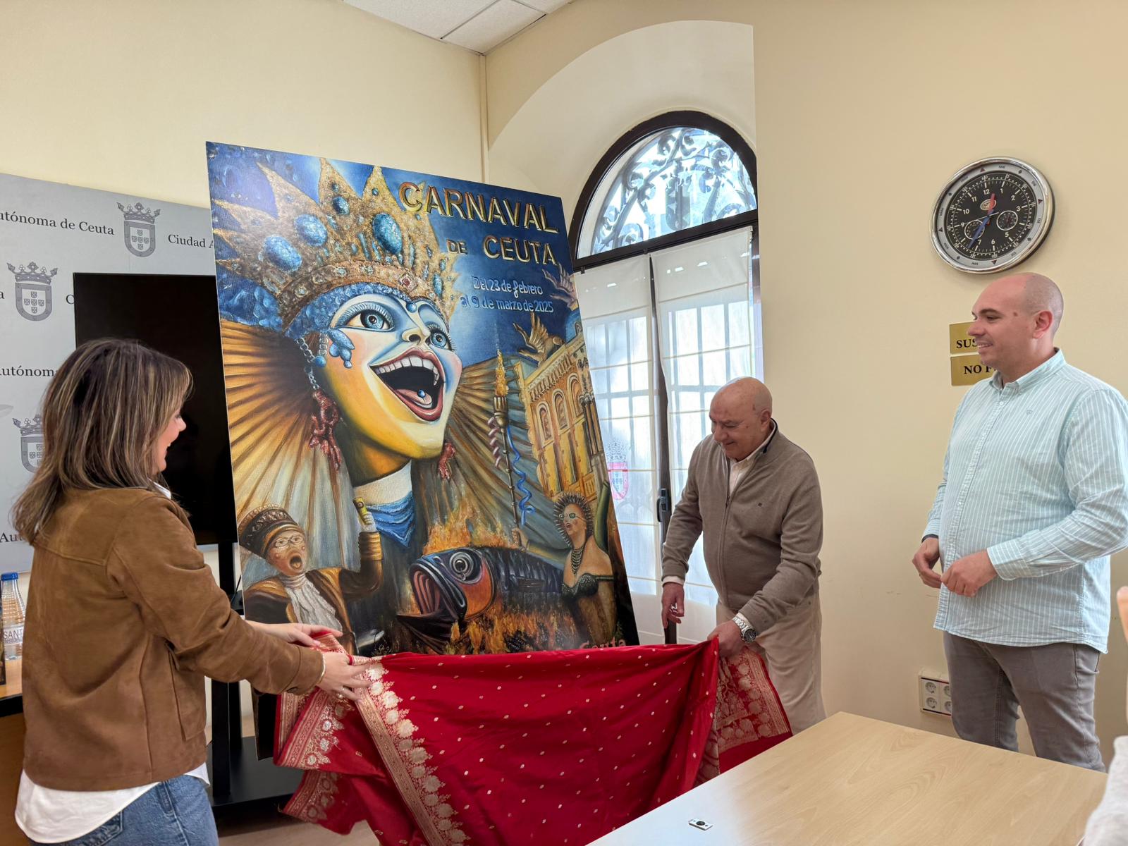 Pilar Orozco, Eduardo Ayala y Andrés Peña junto a su cartel ganador del Carnaval 2025