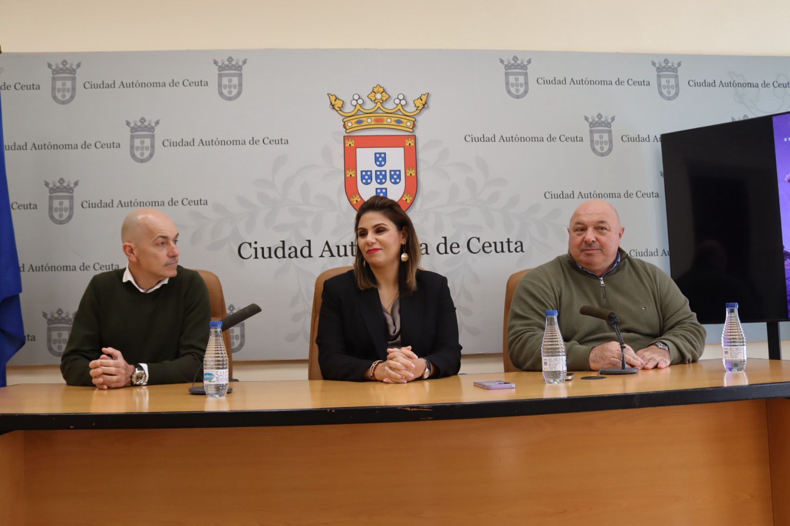 El consejero de Comercio, Turismo, Empleo y Deporte, Nicola Cecchi, y la consejera de Sanidad y Servicios Sociales, Nabila Benzina, acompañados del presidente de la Federación de Ceuta de Triatlón, Jorge Ruiz